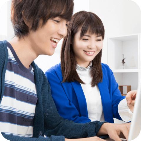 笑顔でパソコンを見ている男女